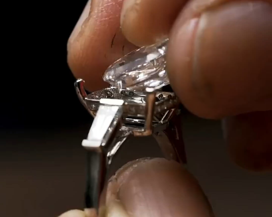 Jeweler setting the center gemstone into a custom ring