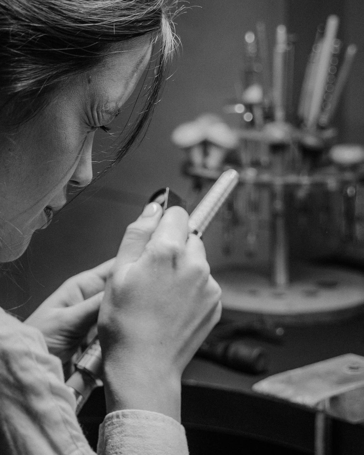 Abbett jeweller resizing and inspecting a ring at the workbench
