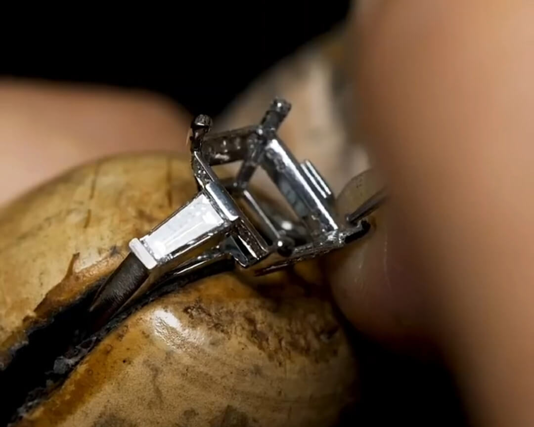 Jeweler refining and shaping a custom ring setting by hand